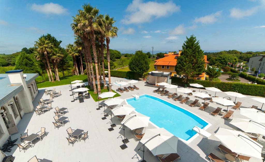 uma vista superior para uma piscina com cadeiras e guarda-sóis em Hotel La Palma de Llanes em Llanes