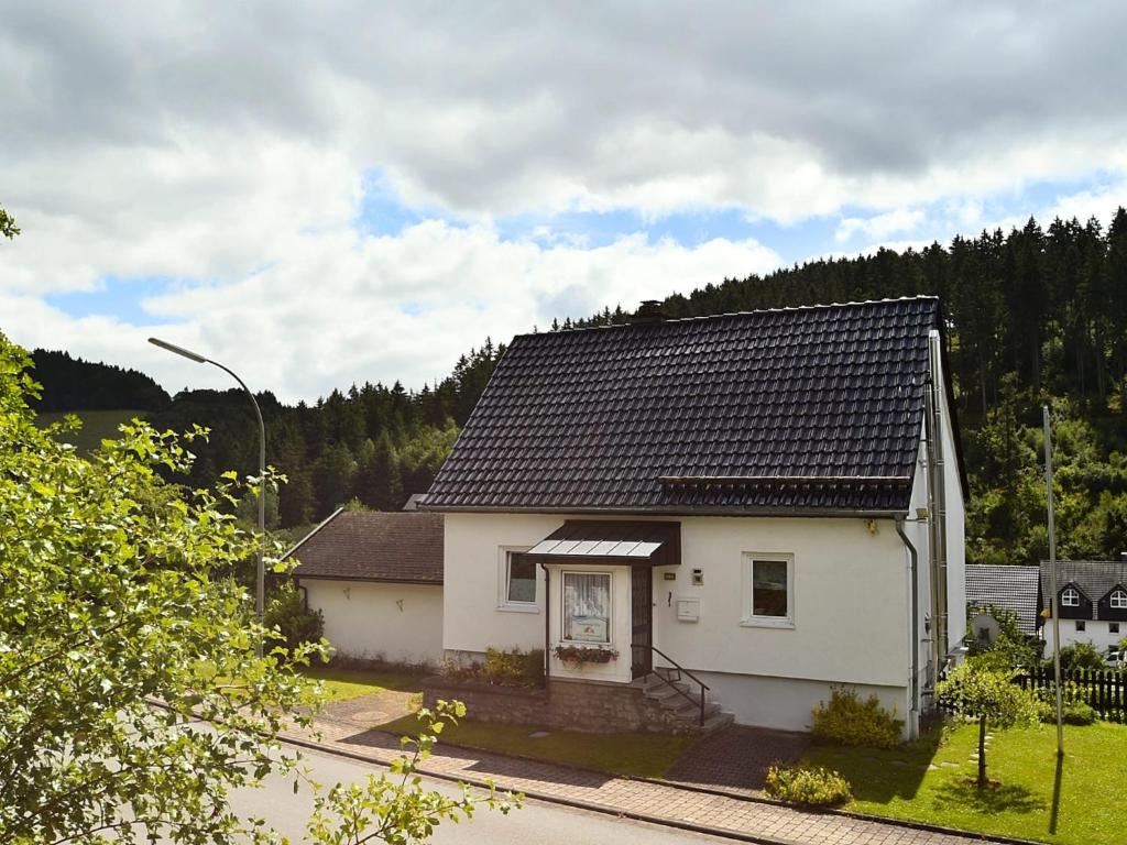a white house with a black roof at Charmantes Ferienhaus in Deifeld in Medebach