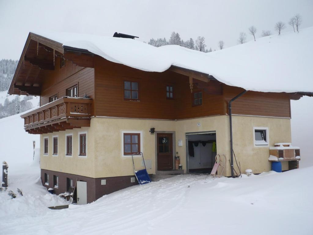 dom w śniegu z śniegiem na dachu w obiekcie Apartment in Wagrain with Stunning Mountain Views w mieście Wagrain