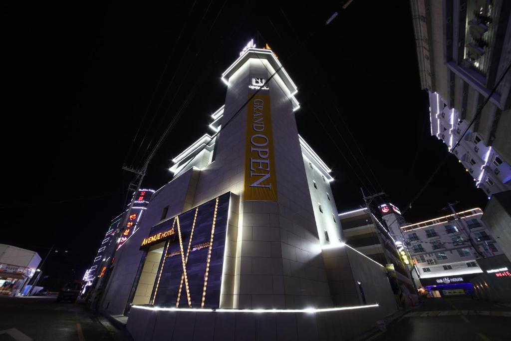 un edificio con un cartel en él por la noche en Avenue Hotel, en Jeonju