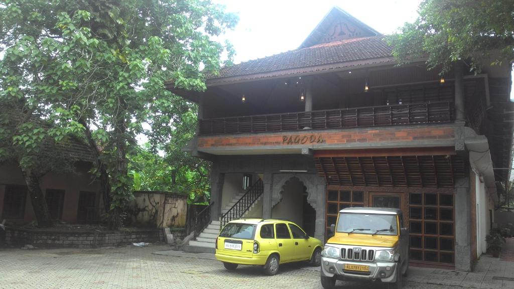 ein gelbes Auto, das vor einem Gebäude parkt in der Unterkunft Pagoda Heritage Inn in Alappuzha