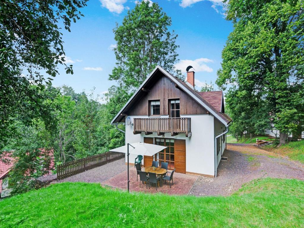 a small house with a table and an umbrella at Mountains Family Retreat in Rudník