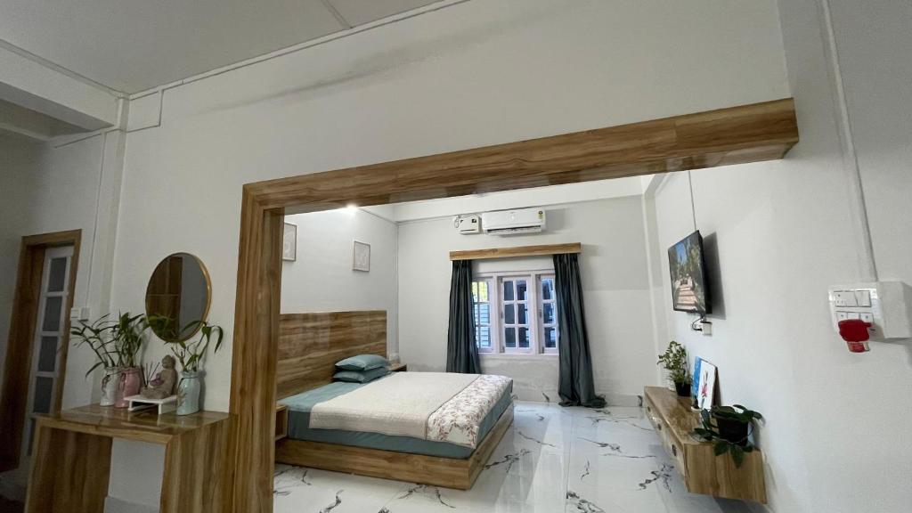 a bedroom with a bed and a mirror in it at LA Mili A Luxury Homestay in North Lakhimpur