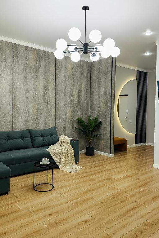 a living room with a green couch and a table at Family Comfort 97 in Uralsk
