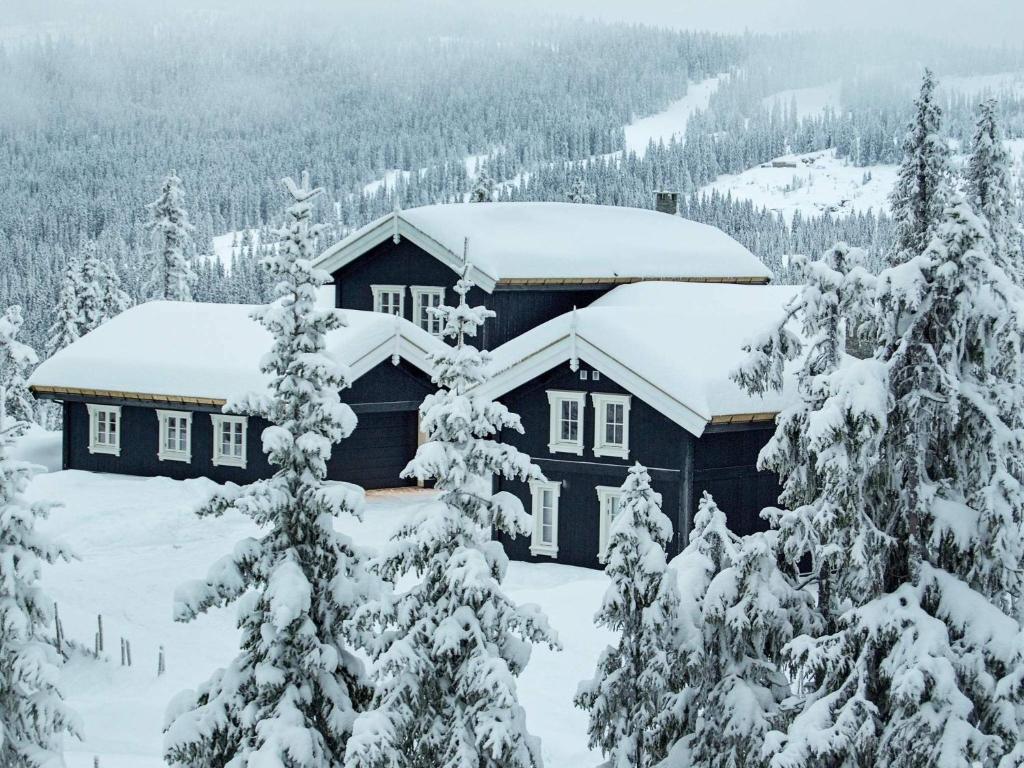 a cabin in the snow with snow covered trees at 12 person holiday home in Fåvang in Favang
