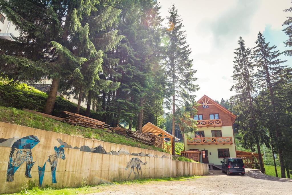 a wall with a painting on it next to a house at Apartments Kvasničník in Belá