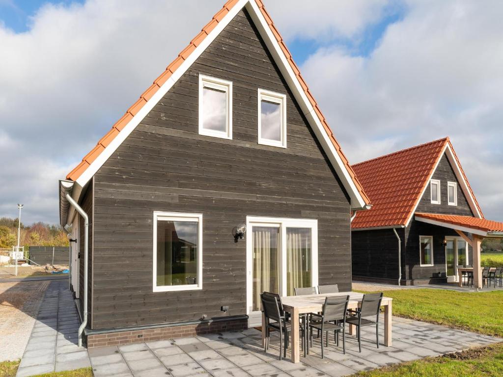 una casa negra con una mesa y sillas en Holiday Home near Scherpenisse Beach, en Scherpenisse