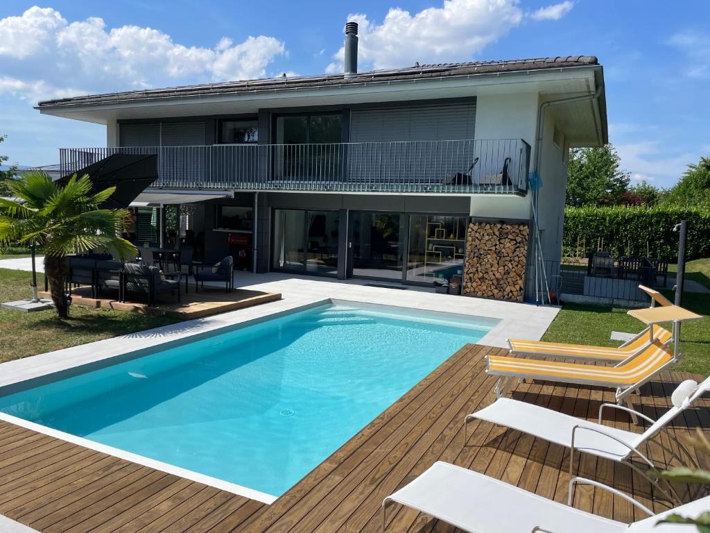 a swimming pool in front of a house at Montaney Guests House - EPFL in Ecublens