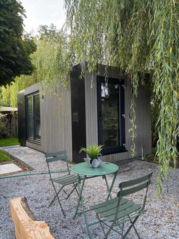 Containers aménagé au cœur des chants des grenouilles في هوتون: فناء فيه طاولة وكراسي تحت شجرة