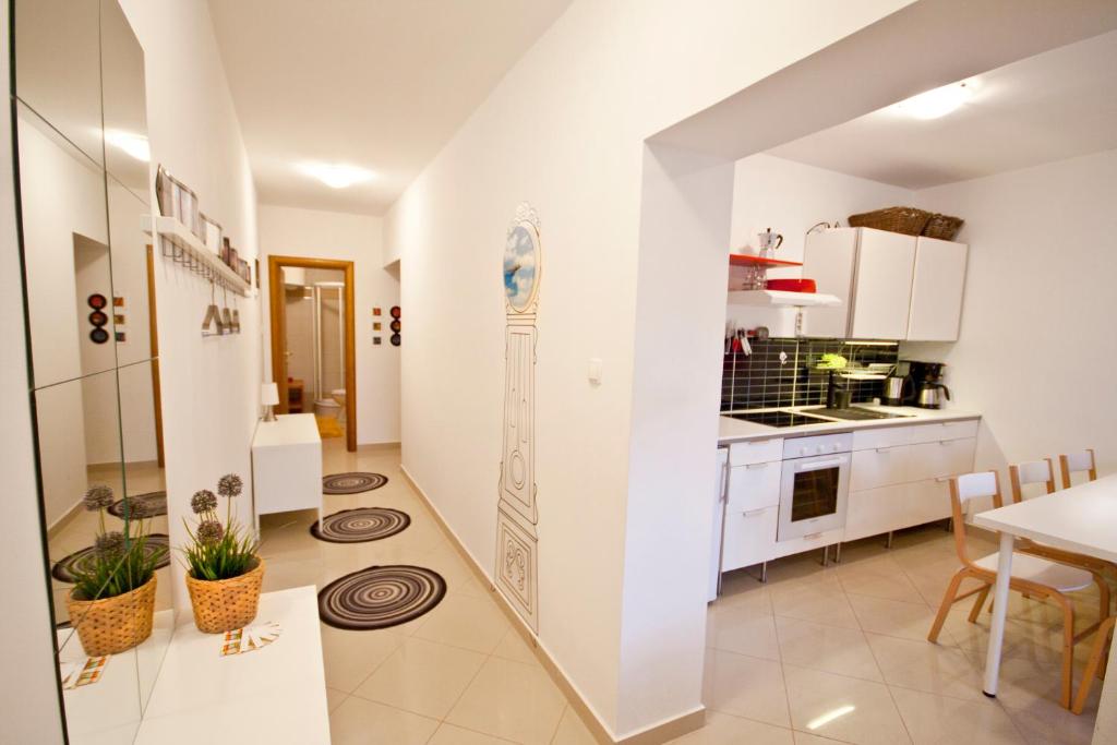 a kitchen and dining room with white walls at Adela Apartments in Dramalj