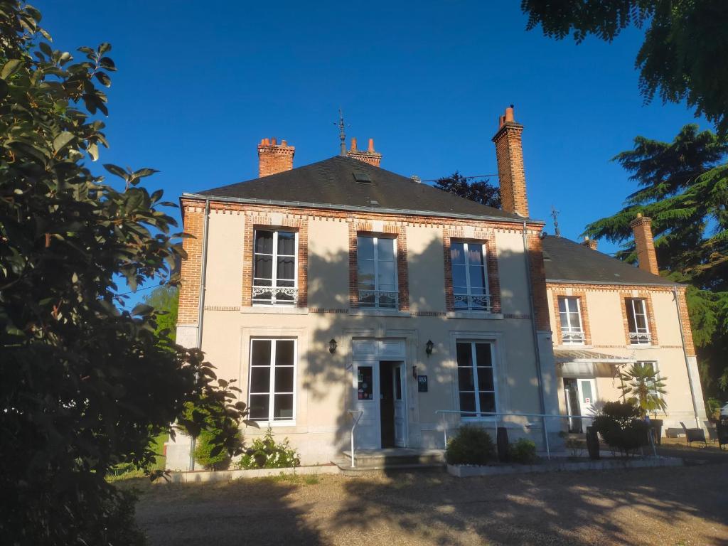 a white house with two chimneys on top of it at Logis Hotels Restaurants- Villa des Bordes in Cléry-Saint-André