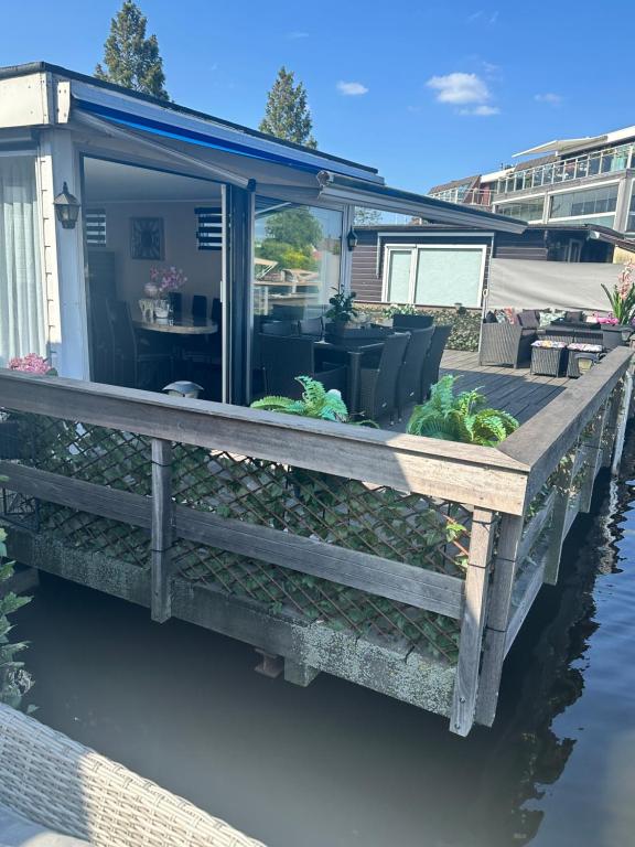 a house with a deck on the water at woonboot de dobber loosdrechtse plassen 6-8 personen in Loosdrecht