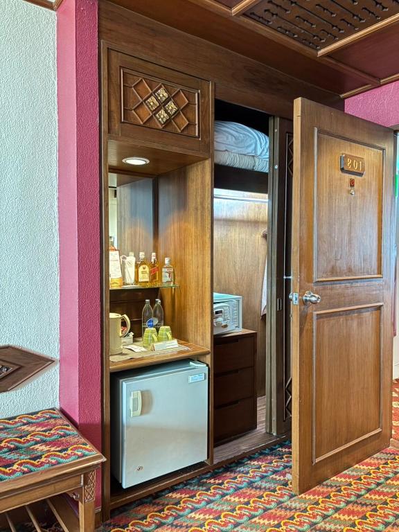 A built-in refreshment and storage unit sits beside the open entrance door.