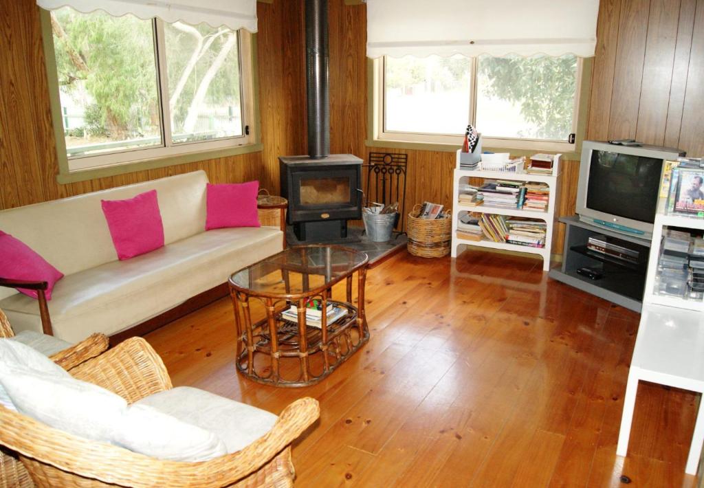 a living room with a couch and a stove at Inlet Side Eden in Inverloch