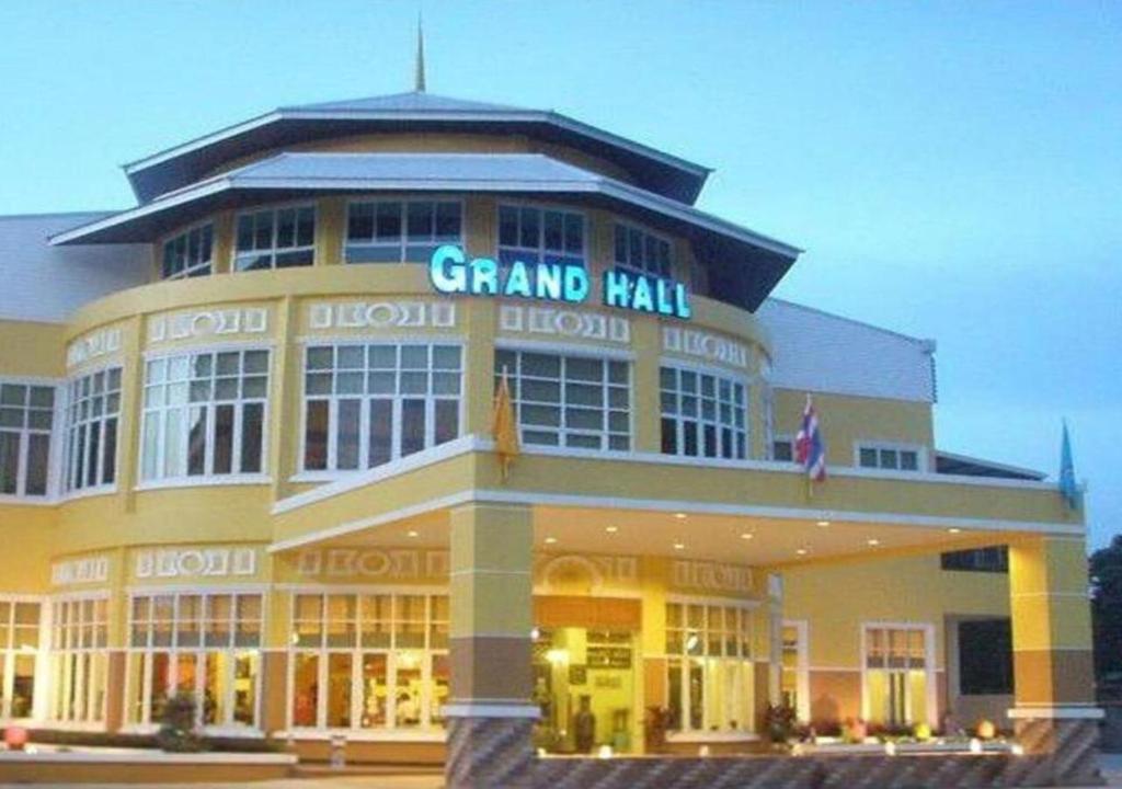un grand bâtiment avec une enseigne au sommet dans l'établissement Grand Hill Resort and Spa, à Nakhon Sawan