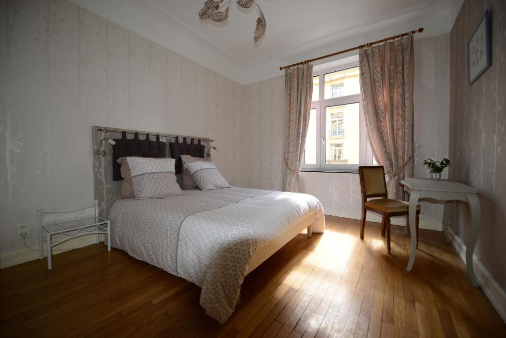 een slaapkamer met een bed, een raam en een stoel bij Gites de l'Austrasie in Metz