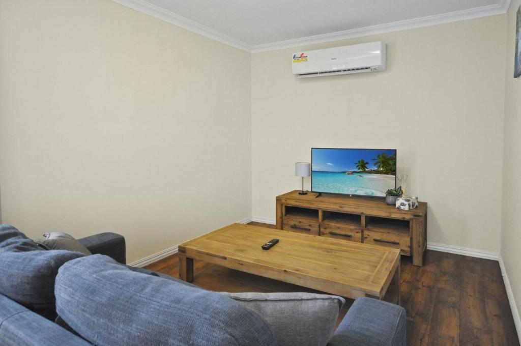 a living room with a couch and a table and a tv at Pilbara Cabin Affordable 1x1 in Port Hedland