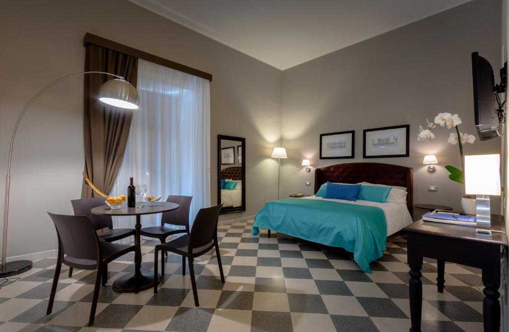 1 dormitorio con 1 cama, mesa y sillas en Hotel Moderno, en Trapani
