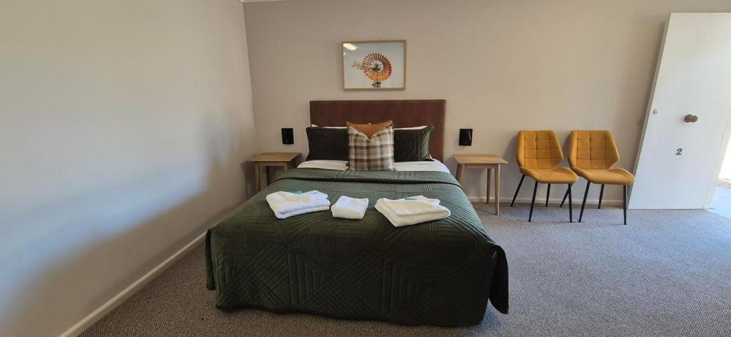 a bedroom with a bed with two towels on it at The Molong Motor Inn in Molong