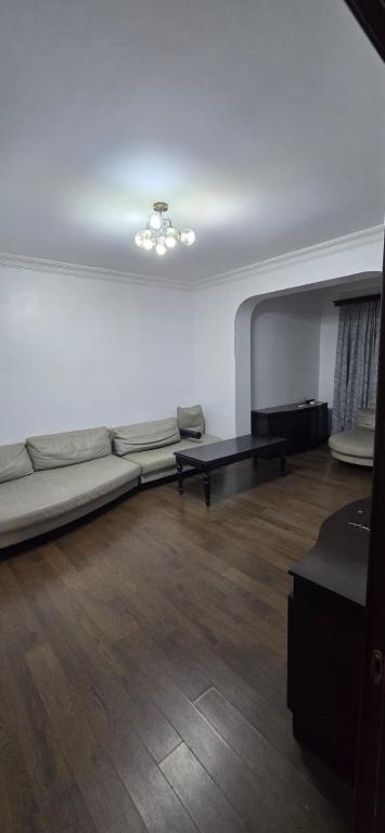 a living room with a couch and wooden floors at vapollo apartment in Batumi