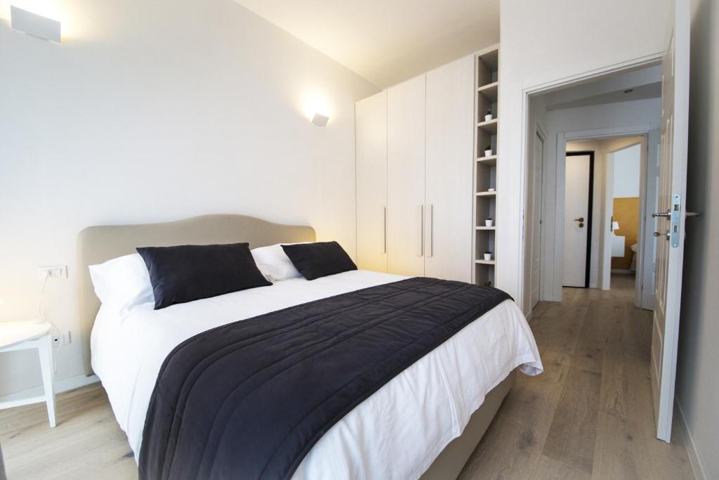 een witte slaapkamer met een groot bed en een hal bij TwoBros Apartment in Florence