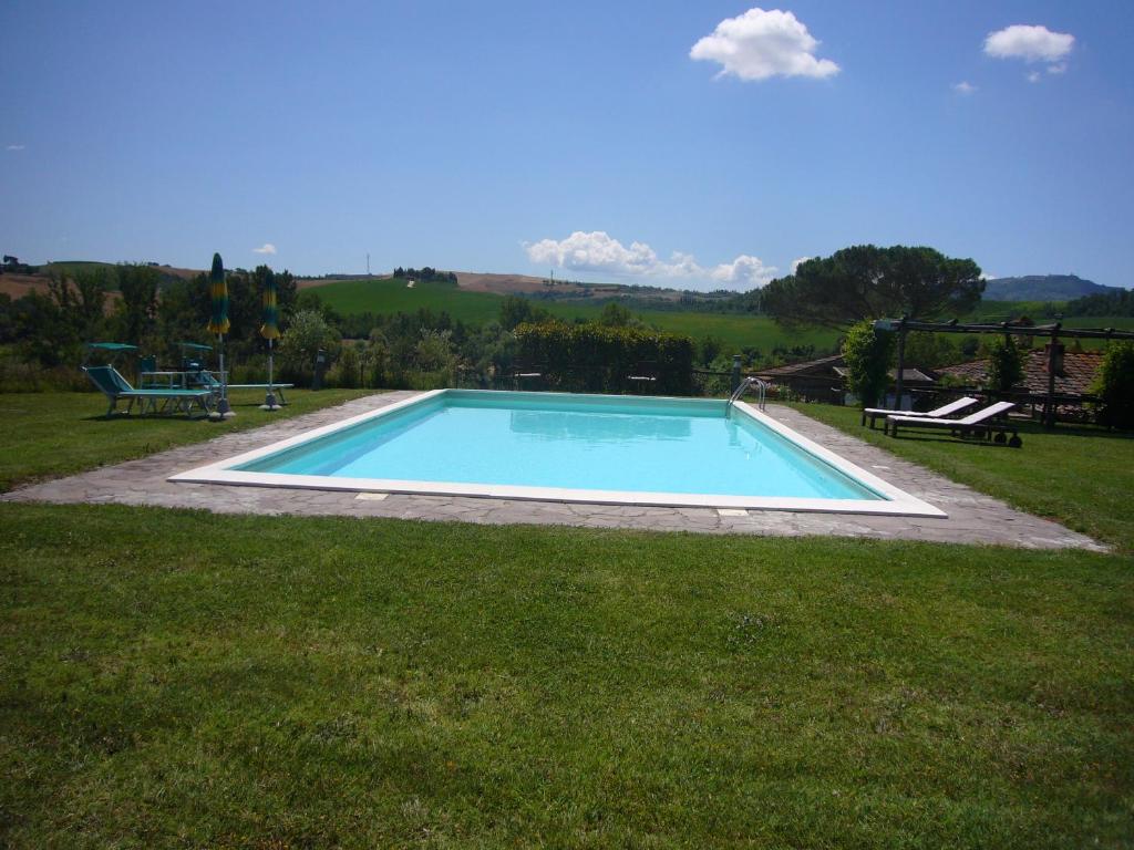 a swimming pool in the middle of a grass field at Casa Vacanze Fornace in Buonconvento