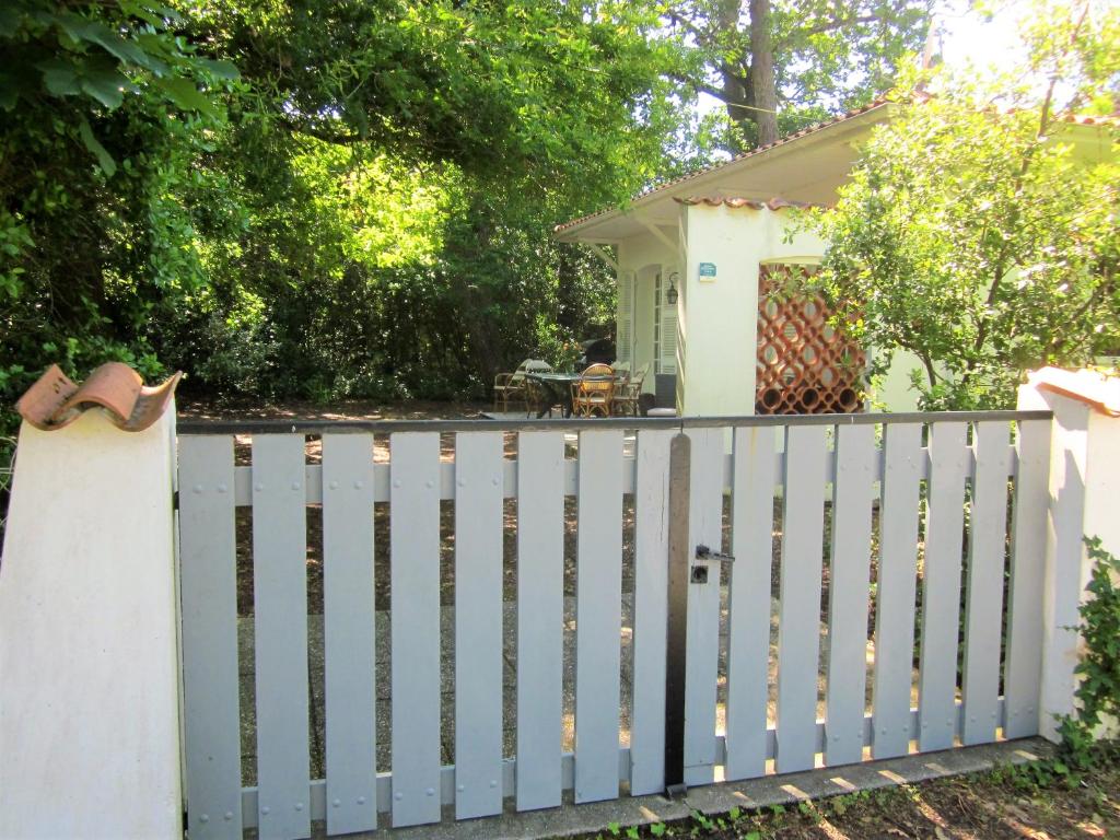 a white fence in front of a small house at RONCE, mer à 1mn,10mn velodyssee, port, travail, thalasso détente, cure, ,,en XXL ! in Ronce-les-Bains