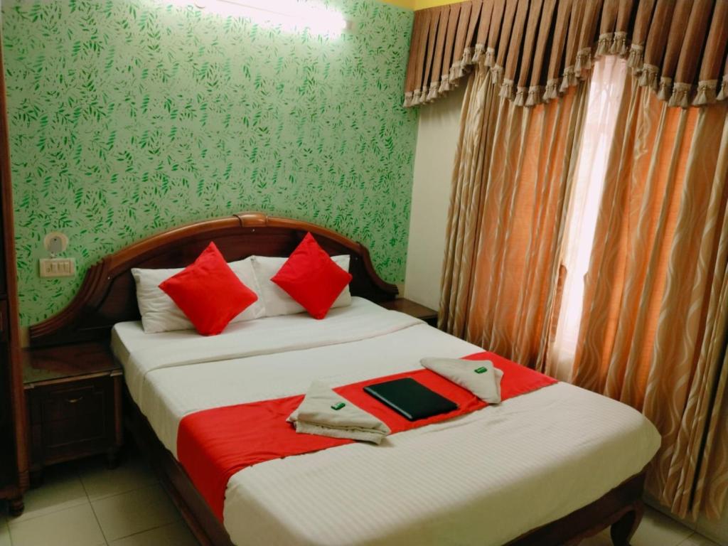 sypialnia z dwoma łóżkami z czerwonymi poduszkami w obiekcie Hotel Nila-Drii Palace Siliguri WB w mieście Siliguri