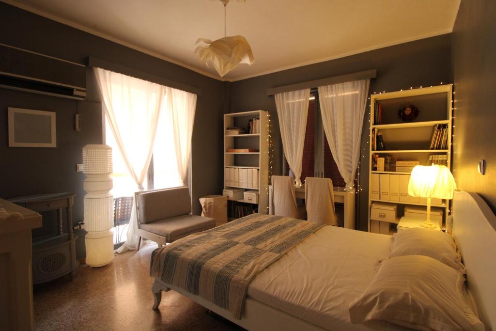 ein Schlafzimmer mit einem Bett, einem Stuhl und einem Fenster in der Unterkunft Charming Seaside Flat in Khalkoútsion