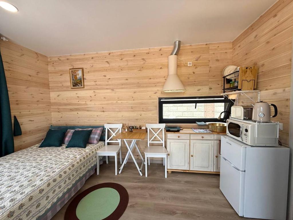 a bedroom with a bed and a kitchen with a table at Guest House Cholpon-Ata, Aitmatov Street 104-10 in Cholpon-Ata