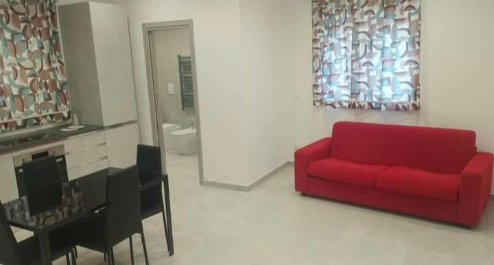 a living room with a red couch and a table at Thysia in Conversano