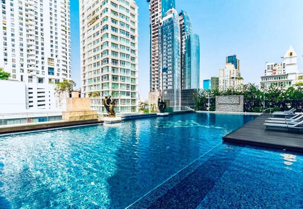 バンコクにあるIvy Thonglor Luxury Condo with Swimming Pool, Fast Wifiの高層ビルが立ち並ぶ都市の大型スイミングプール