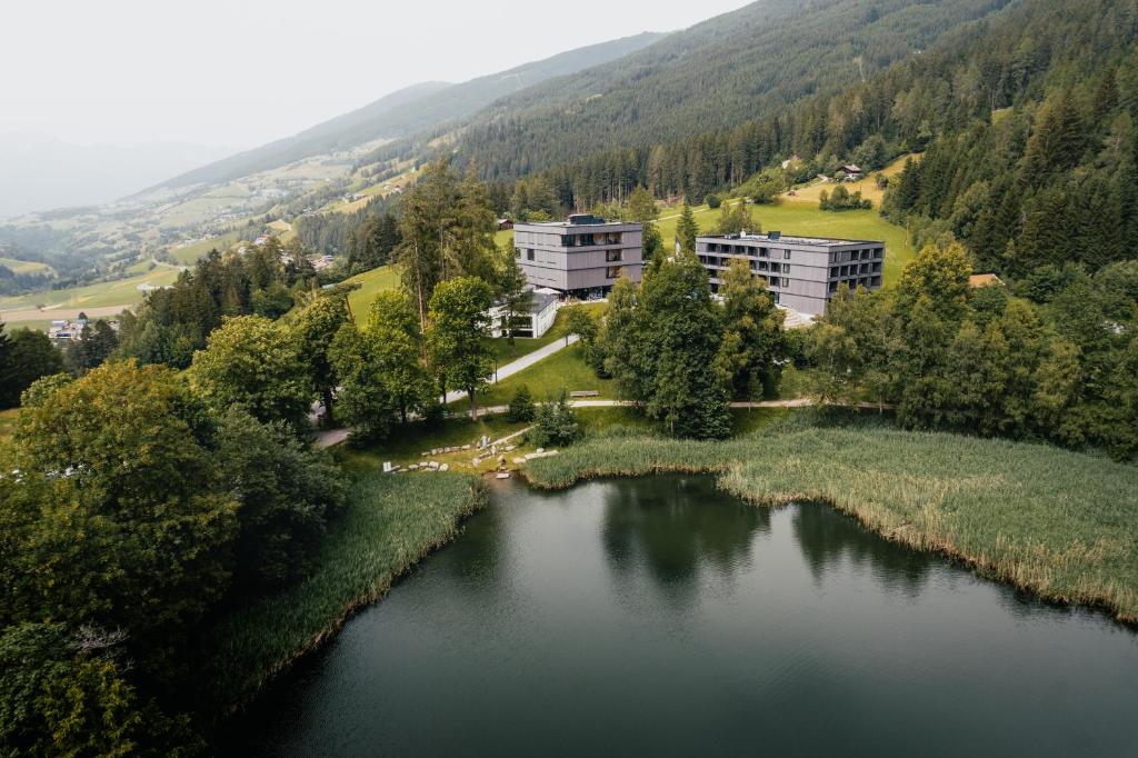 an aerial view of a lake with buildings and trees at St Michael Alpin Retreat in Matrei am Brenner