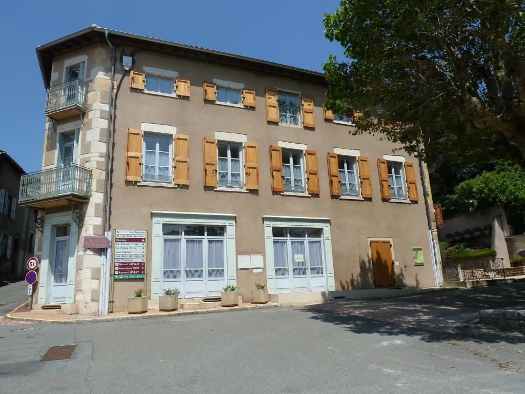 un bâtiment avec des fenêtres sur le côté d'une rue dans l'établissement Les Gîtes de La Fontaine, à Jullié