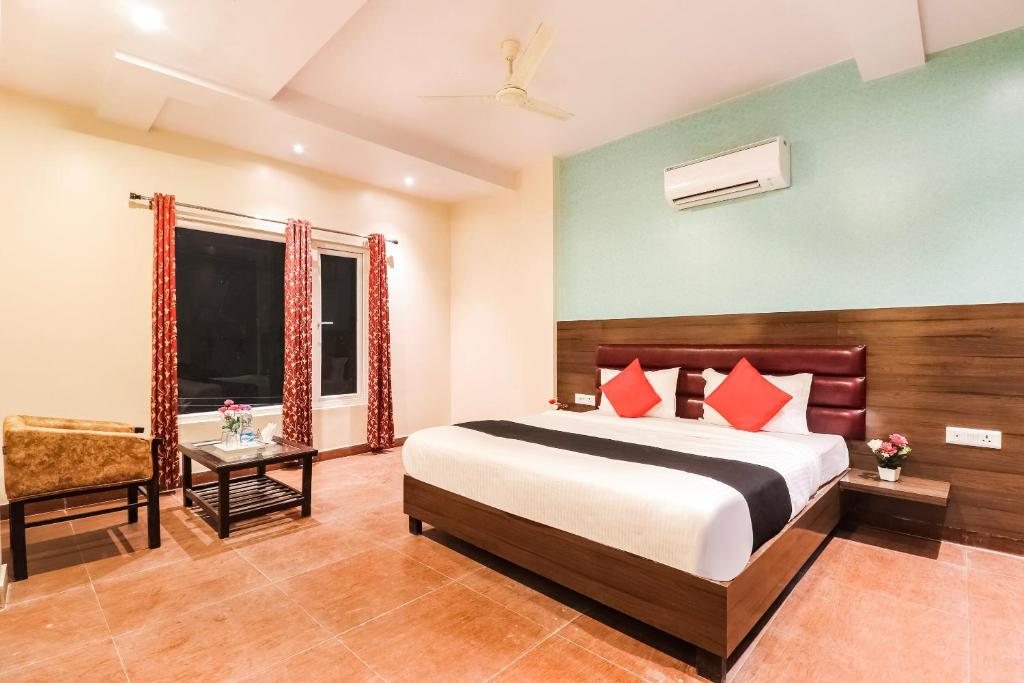 a hotel room with a bed and a chair at Collection O Gaytri Palace in Lucknow