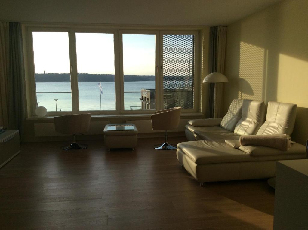 uma sala de estar com um sofá e algumas janelas em Ferienwohnung Sonwik em Flensburg