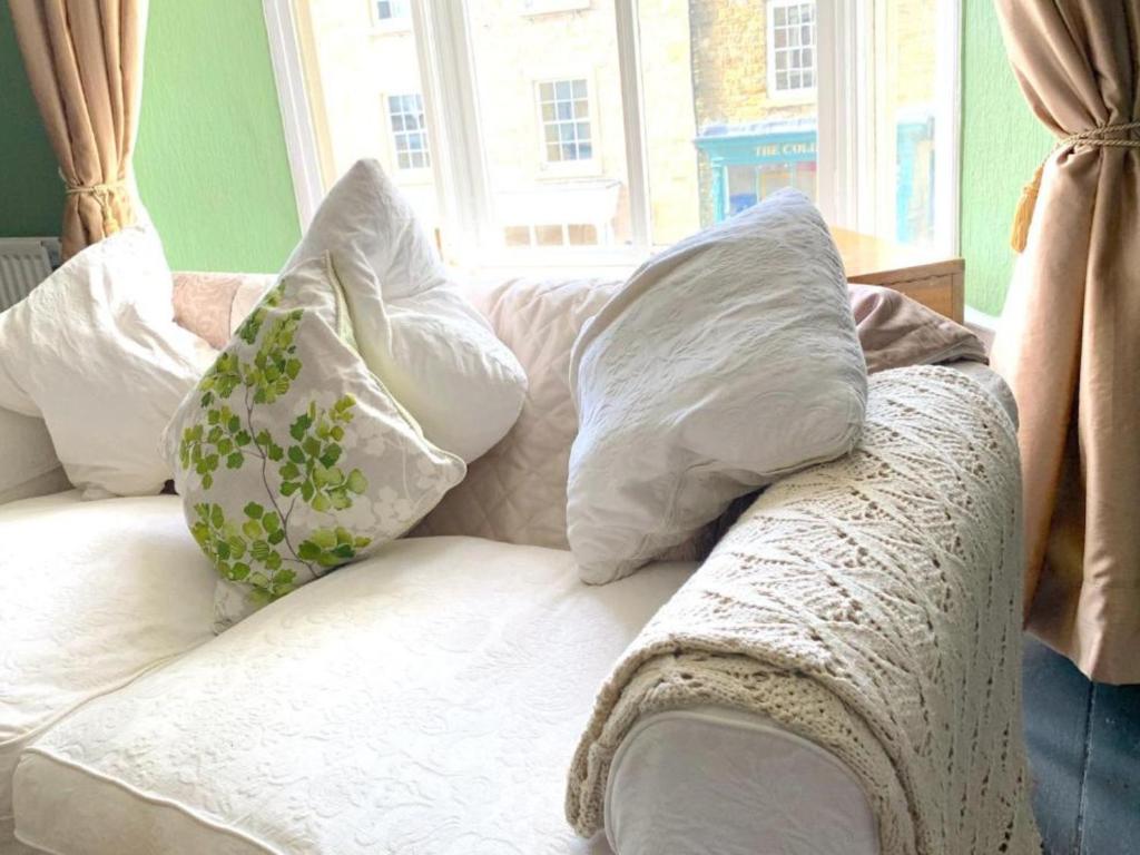 a white couch with pillows on it with a window at Spacious Georgian Apartment, Central Barnard Castle. in Barnard Castle