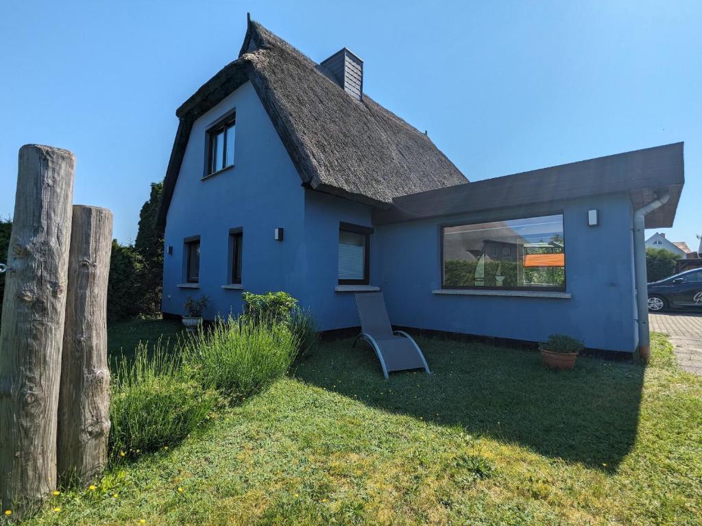 een blauw huis met een stoel in de tuin bij Dat smucke Reethus - OG in Born