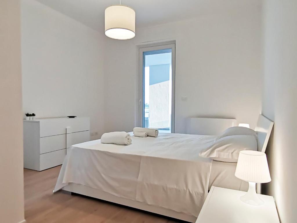 Un dormitorio blanco con una cama grande y una ventana. en BorgoVille, en Bari