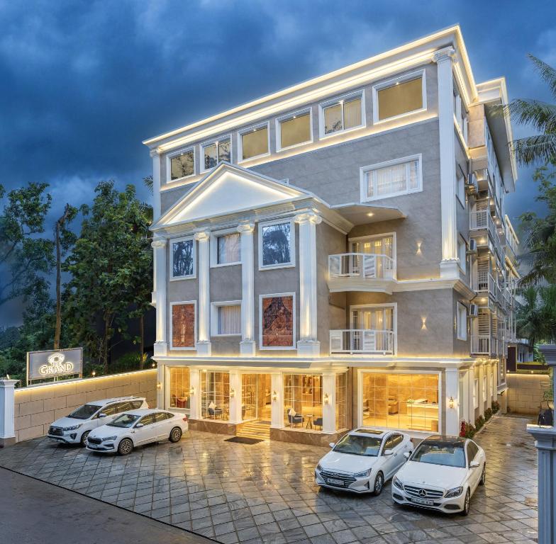 a large building with cars parked in front of it at The Grand in Thekkady