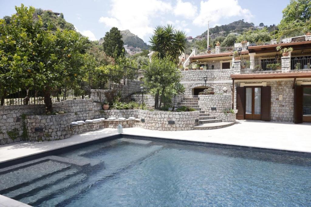 a swimming pool in front of a house at Villa Ragona Taormina in Taormina