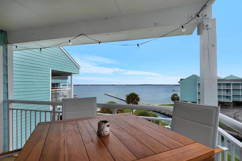 a wooden table on a balcony with a view of the water at Baywatch C10 in Pensacola Beach