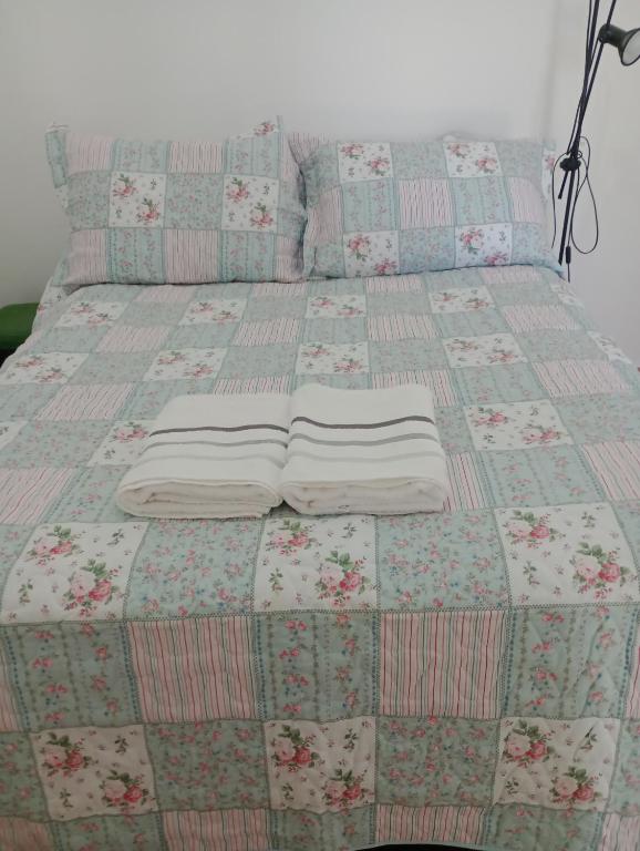 a bed with a quilt and pillows on it at Recanto das Videiras in Maria da Fé