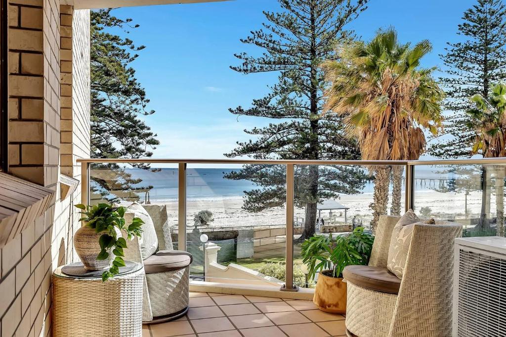 グレネルグにあるGlenelg Outlook - Beachfront Stay by Moseley Squareの椅子とビーチの景色が見えるバルコニー