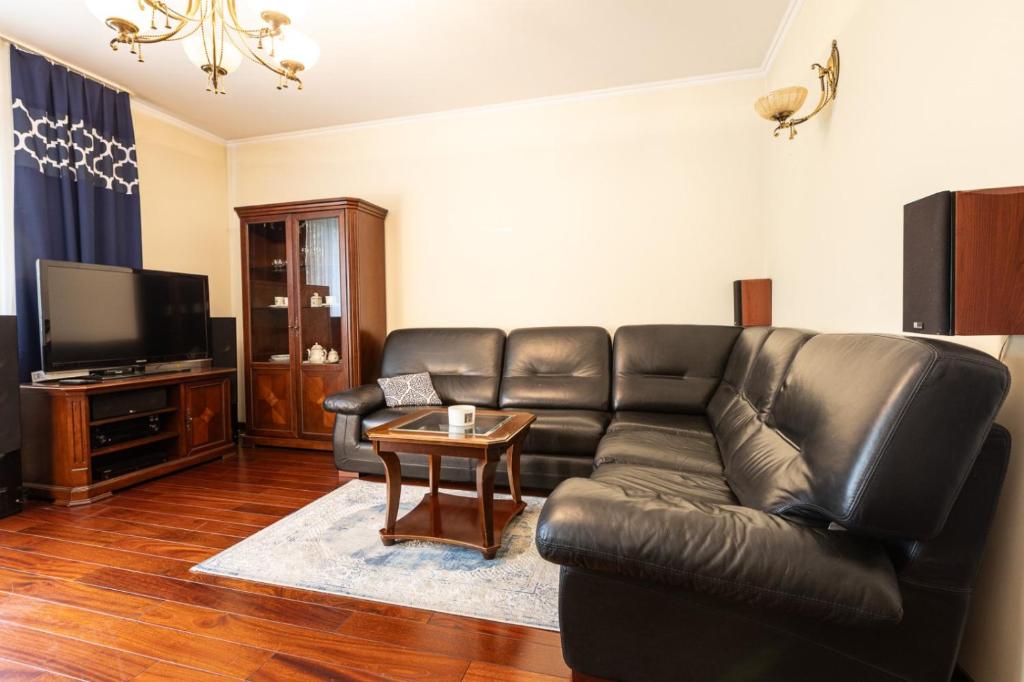 un soggiorno con un divano in pelle e un tavolo di Apartament Kraków & Cracow Apartment 70m2 a Skorka