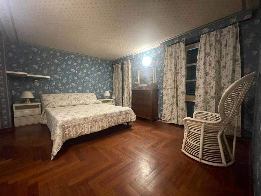 a bedroom with a bed and a chair in it at LA VOLPINA - Terrazza in Centro in Ovada