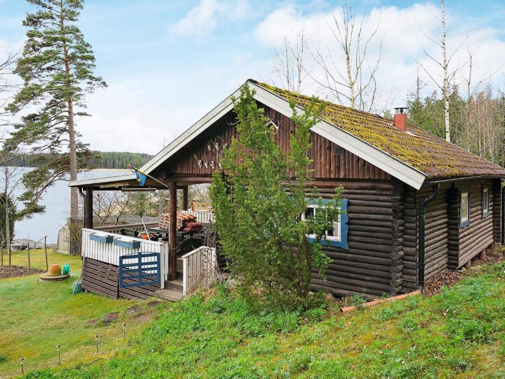 a log cabin with a gazebo on a hill at 4 person holiday home in Vetlanda in Lillarp