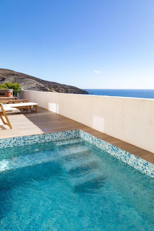a swimming pool with a view of the ocean at Seaside Home Jacuzzi Pool Free Surf Retreat in El Médano