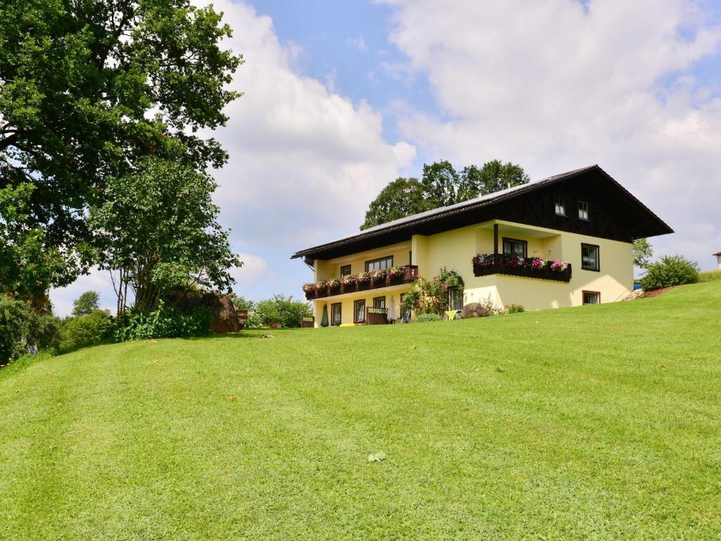 a house on a hill with a large grass field at Ferienwohnung in Drachselsried für 2 Personen in Drachselsried