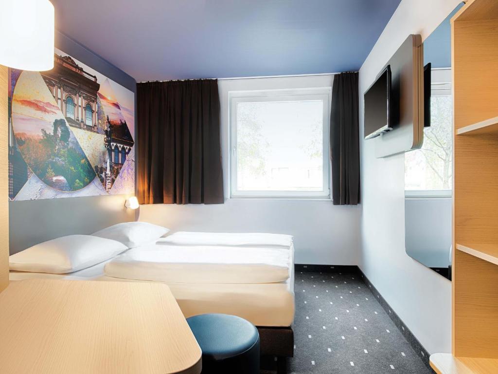 Una habitación de hotel con dos camas y una ventana. en B&amp;B Hotel Kaiserslautern, en Kaiserslautern
